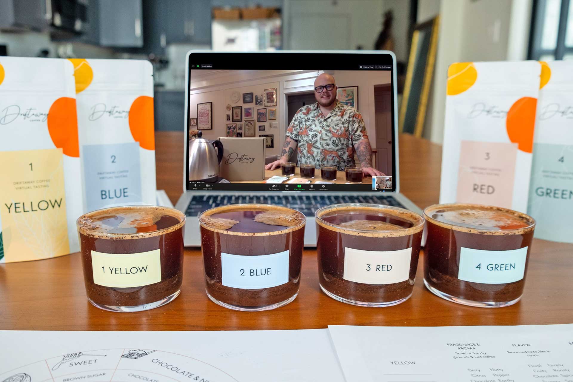 Four samples of coffee alongside a laptop computer