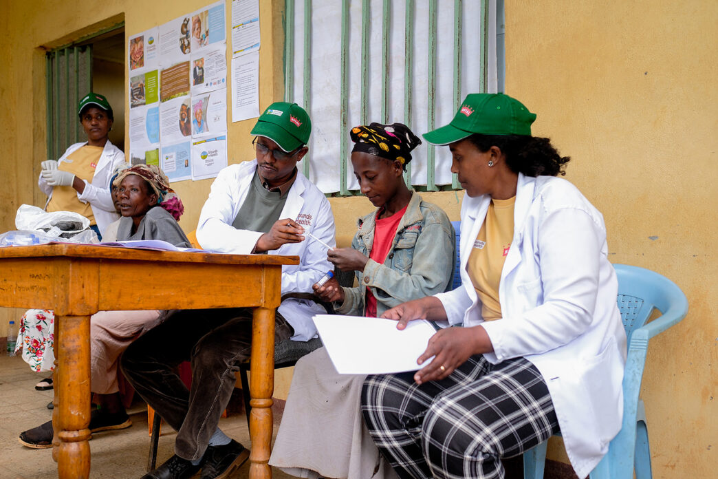 grounds for health volunteers at screening site, February 2025, signing up women for cervical cancer screening.