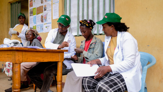 grounds for health volunteers at screening site, February 2025, signing up women for cervical cancer screening.