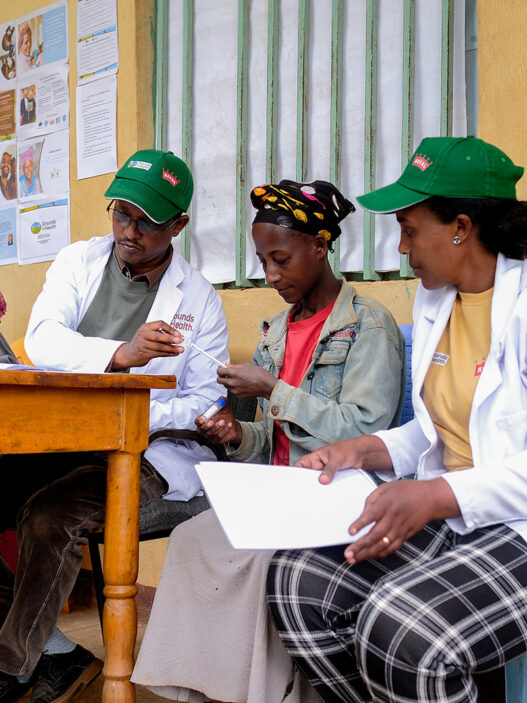 grounds for health volunteers at screening site, February 2025, signing up women for cervical cancer screening.